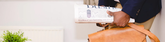 Closeup of man holding Business newspaper | 7 Creative Ways to Reach Local Clients | Brighter Vision | Therapist Websites & Marketing for Therapists | Blog for Therapists