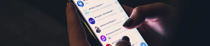 Person using cell phone in dark room | Why & How to Keep the “Social” in Your Social Media Marketing | Brighter Vision | Marketing Blog for Therapists