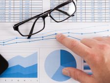 finger pointing to charts and graphs